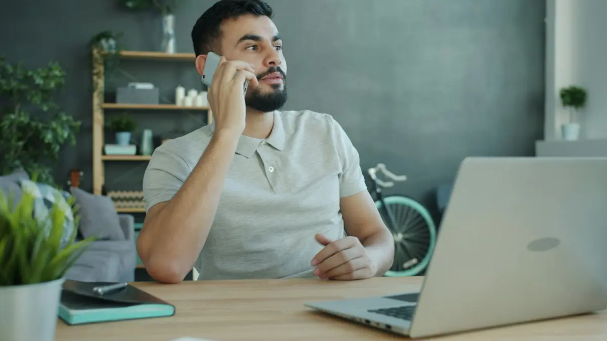 Person on a phone call at a desk with paperwork