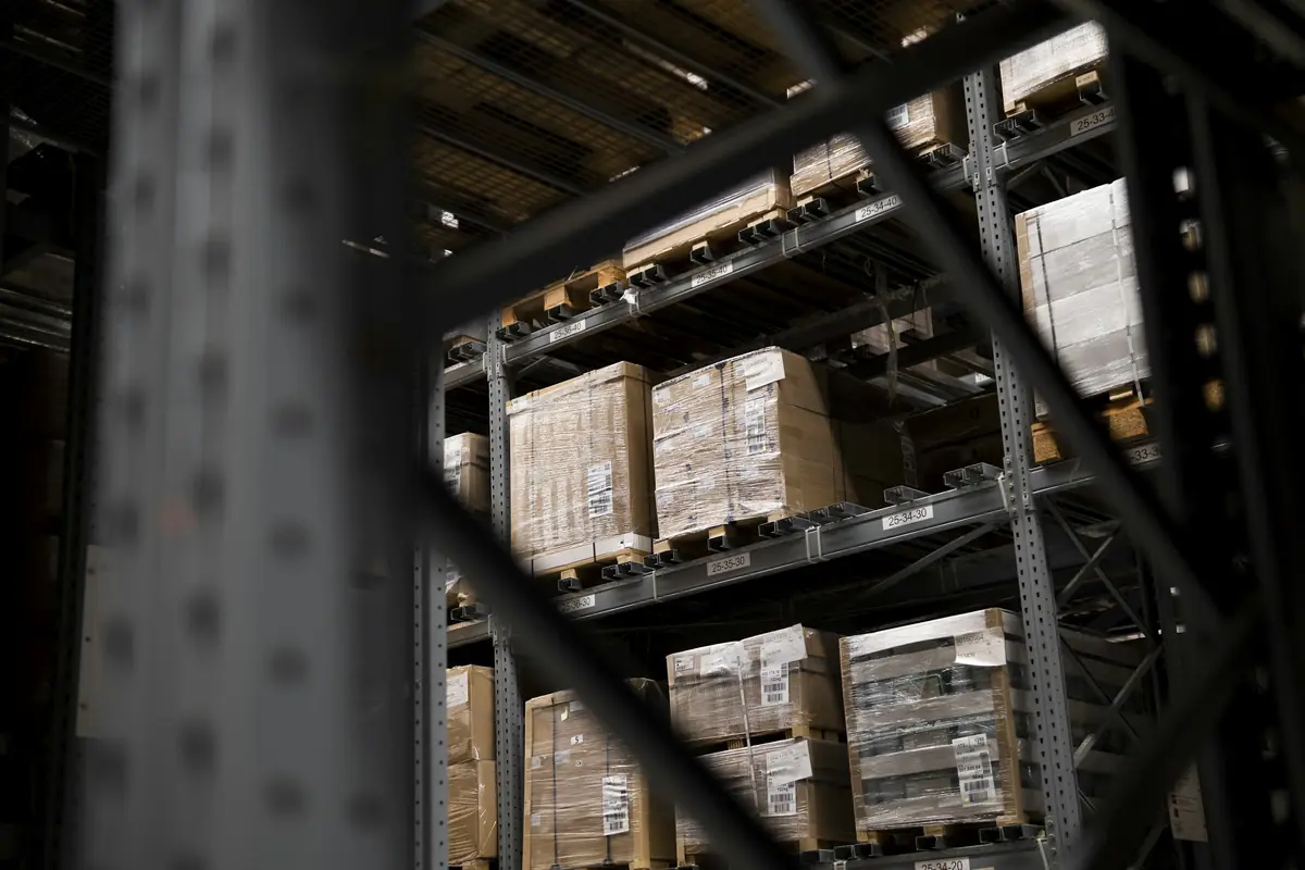 Dimly lit warehouse shelves stacked with cartons